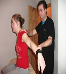 Young lady having Sports Massage for Whiplash injury on neck and shoulders in Cardiff